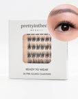 Eyelash packaging with a close-up of an eye wearing the press on cluster lashes on a white background