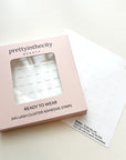 Pink box of lash cluster glue strips with a white background