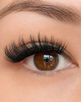 Close-up of an eye with long, dramatic press on lash clusters and a well-groomed eyebrow.