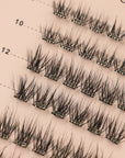 close up of pre glued natural style cluster lashes against a peach background
