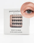 Eyelash packaging with a close-up of an eye wearing the pre-glued cluster lashes on a white background