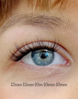 close up woman's blue eye with subtle false lashes showing dark lash line and fluttery light tips