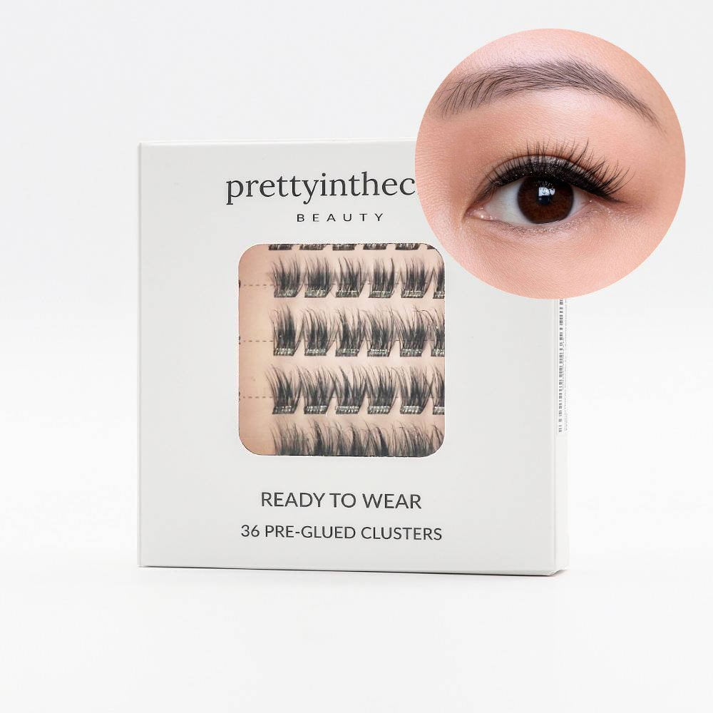 Eyelash packaging with a close-up of an eye wearing the press on cluster lashes on a white background