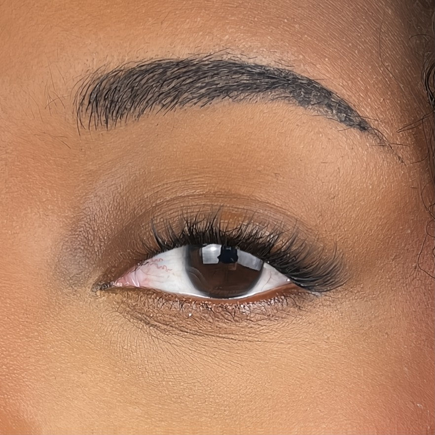 close up of womans eyes with false lashes showing dark lash line and light fluffy tips