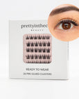 Eyelash packaging with a close-up of an eye wearing the press on lashes on a white background