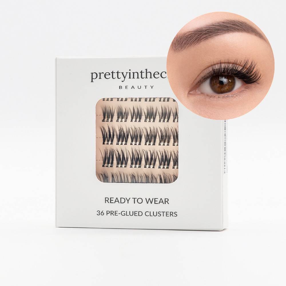 Eyelash packaging with a close-up of applied self adhesive eyelash cluster on a white background