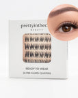 Eyelash packaging with a close-up of applied self adhesive eyelash cluster on a white background